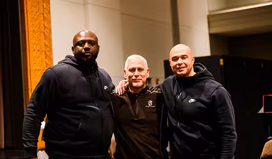 Three men gathered smiling for a photo